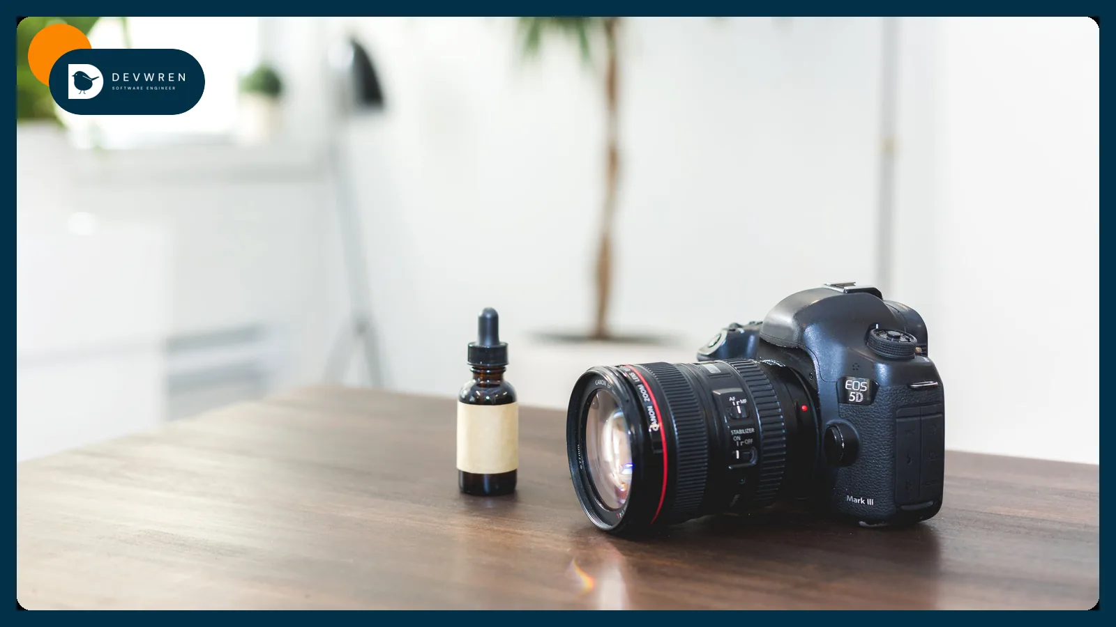 A camera on a table next to a small product bottle