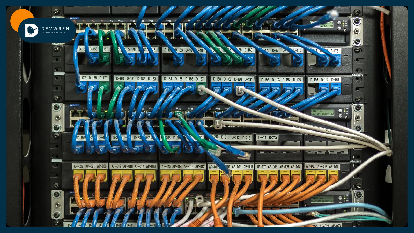 A server rack of network switches with rows of blue and orange cables